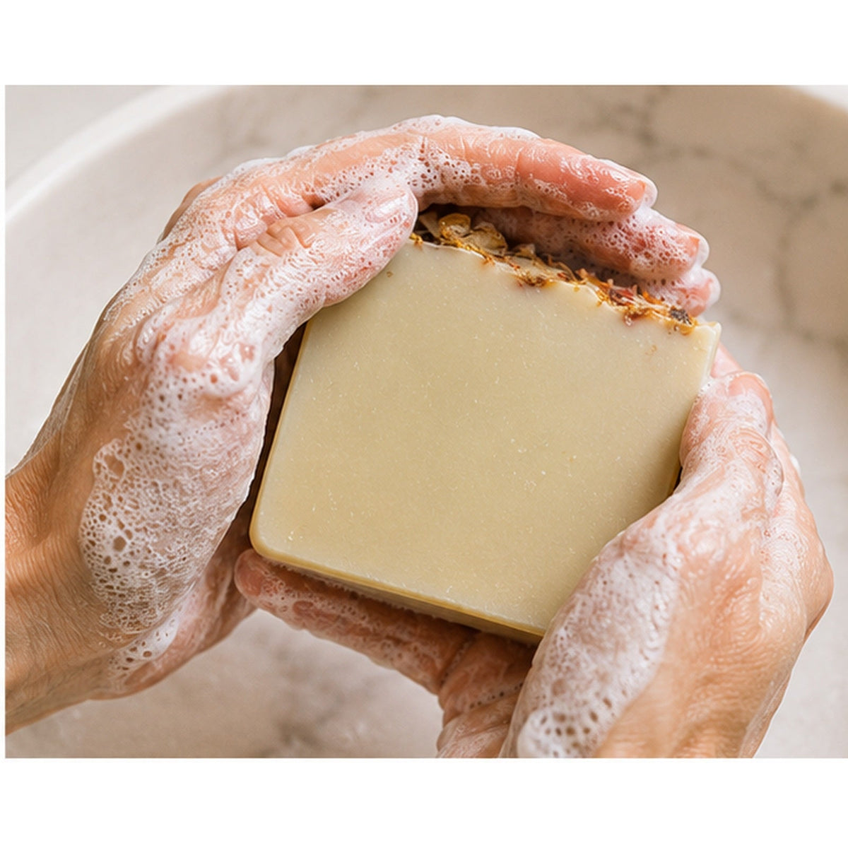 Grounded Citrus Sunrise handmade soap lathered in hands