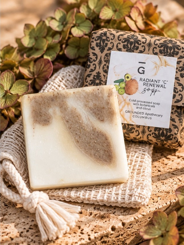 Radiant C Renewal tallow soap bar with amla and olive oil, unwrapped bar beside its wrapped bar and a jute soap saver bag